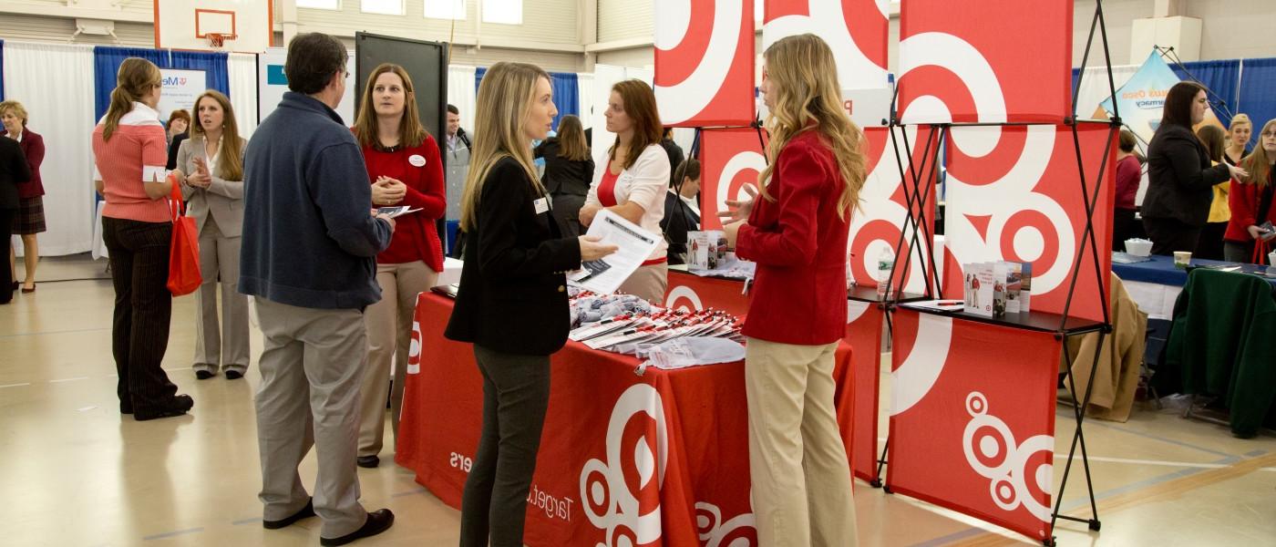 学生 visit with health professionals during a career fair on U N E's Portland Campus 